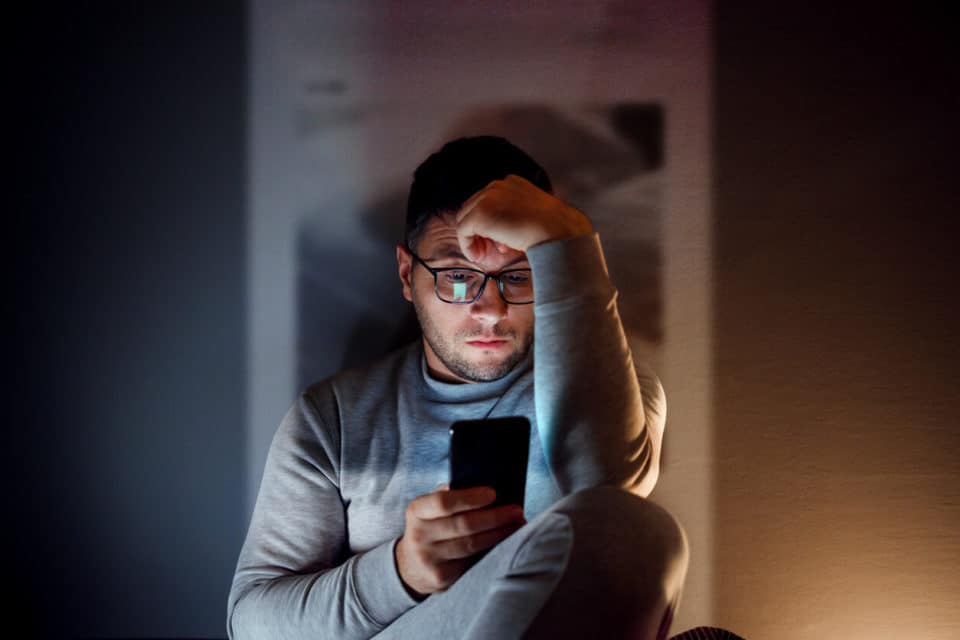 Eating disorders in men - a man reading his phone late at night